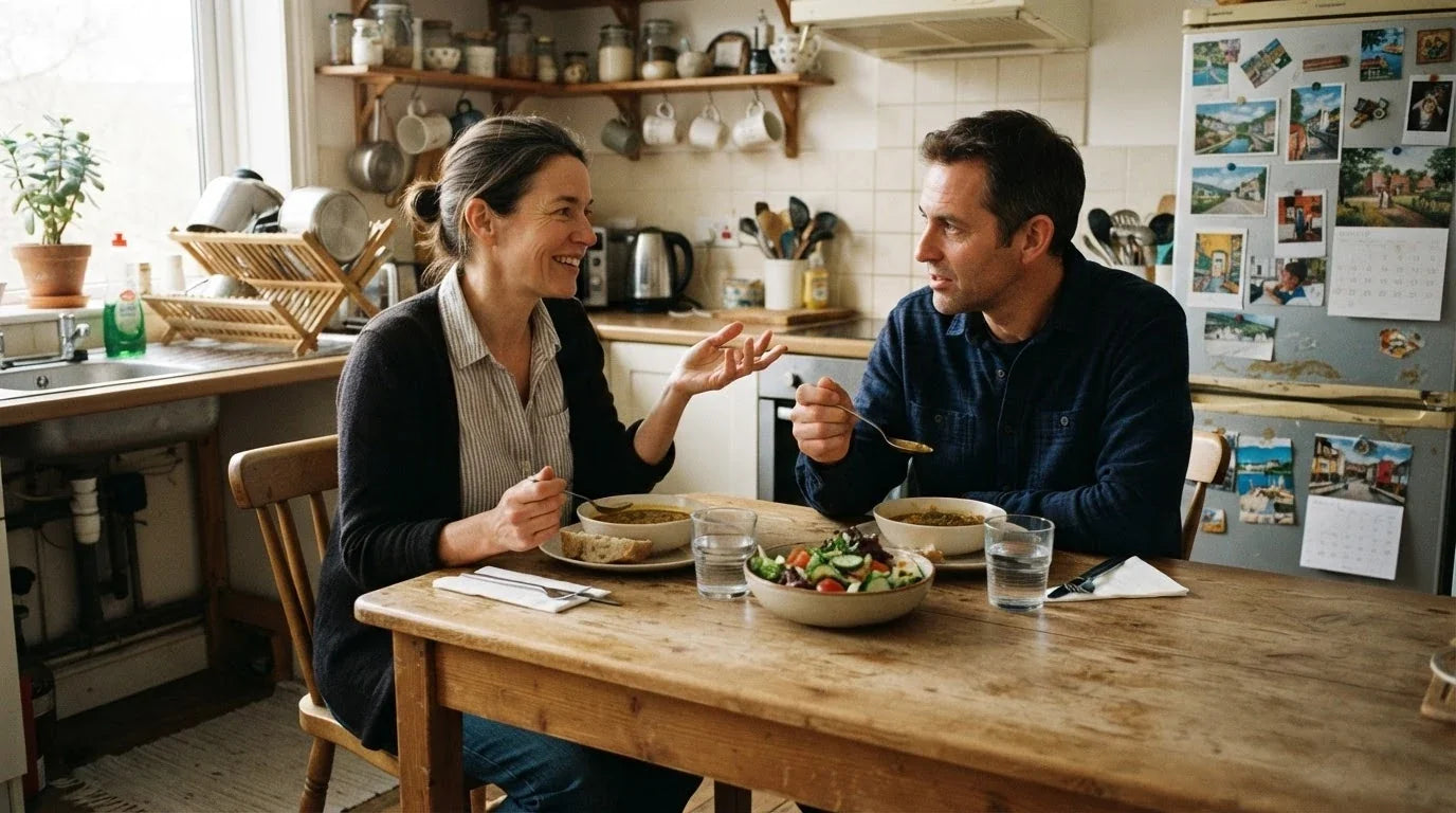 Two adults eating an ordinary balanced lunch together at a kitchen table