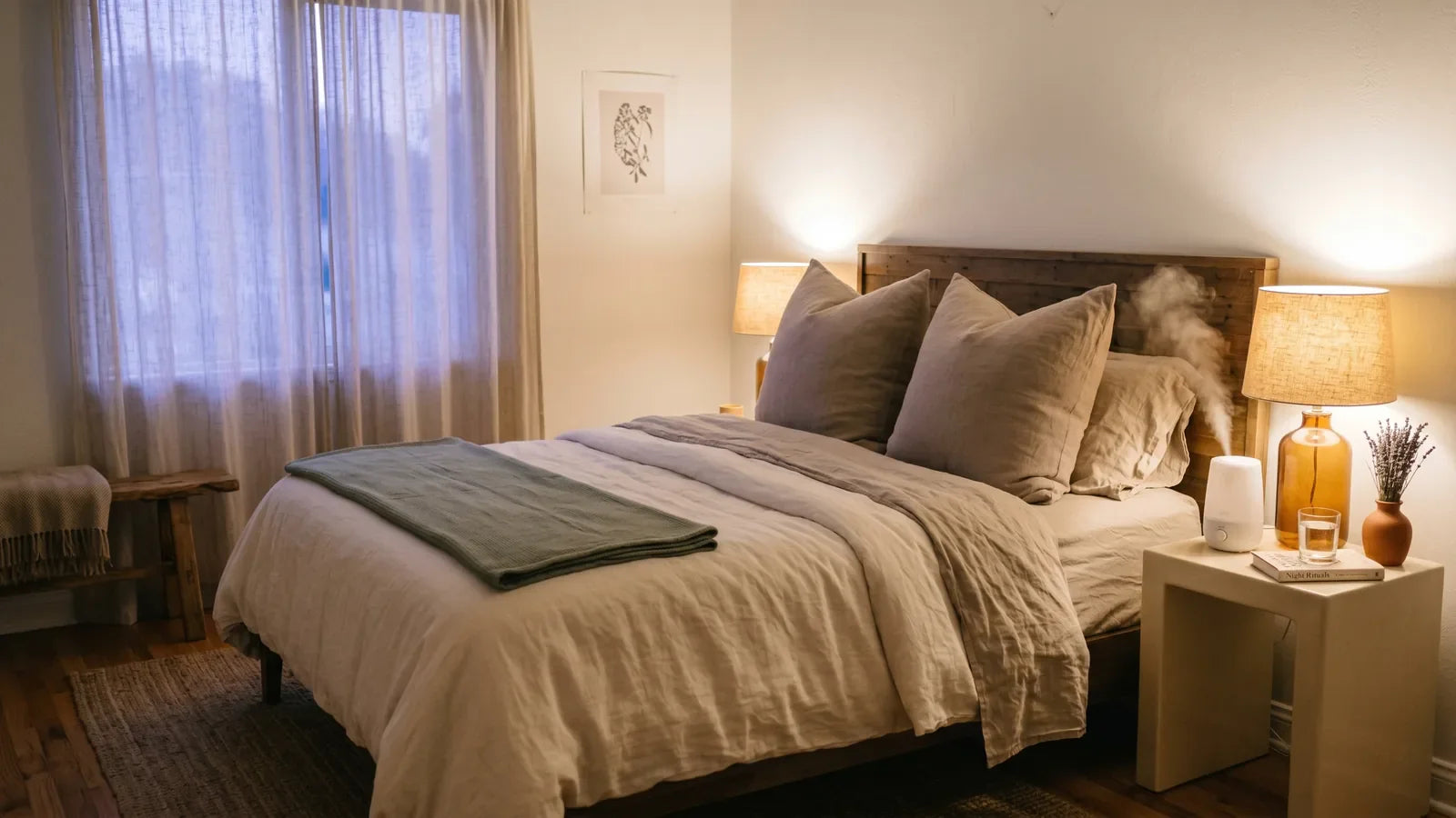 Cozy bedroom at dusk with bed elevated by extra pillows, small humidifier glowing softly on bedside table, warm amber lamp